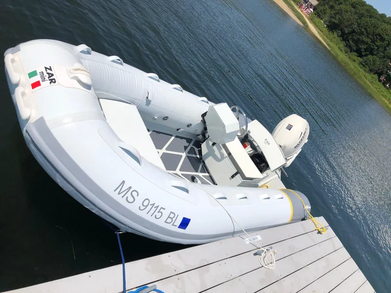 Slide: The Image of 2022 ZAR Mini RIB 14 HDL inflatable boat docked by the water. - 9