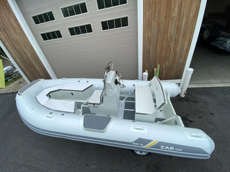The Image of 2022 ZAR Mini RIB 15 HDL Tender 60 Hp inflatable boat in front of a garage. - 0