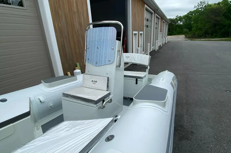 Slide: The Image of 2022 ZAR Mini RIB 15 HDL Tender 60 Hp, docked near storage units. - 2