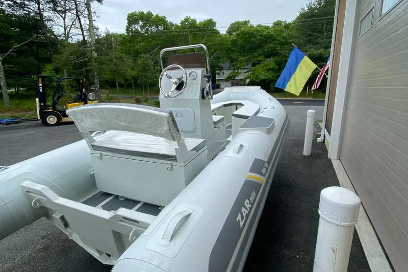 Slide: The Image of 2022 ZAR Mini RIB 15 HDL Tender 60 Hp inflatable boat docked near a garage. - 6