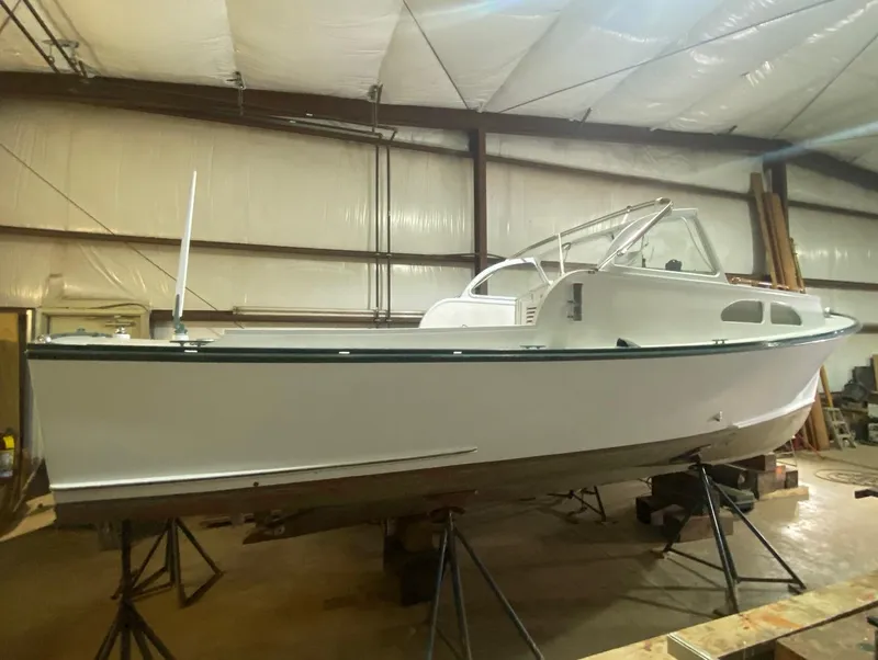 The Image of 1960 Classic Riverside Boat Co. model in a warehouse, white hull, vintage design. - 0