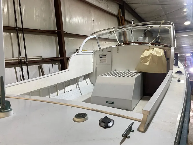 Slide: The Image of 1960 Classic Riverside Boat Co. vessel in storage, showcasing deck and helm details. - 3