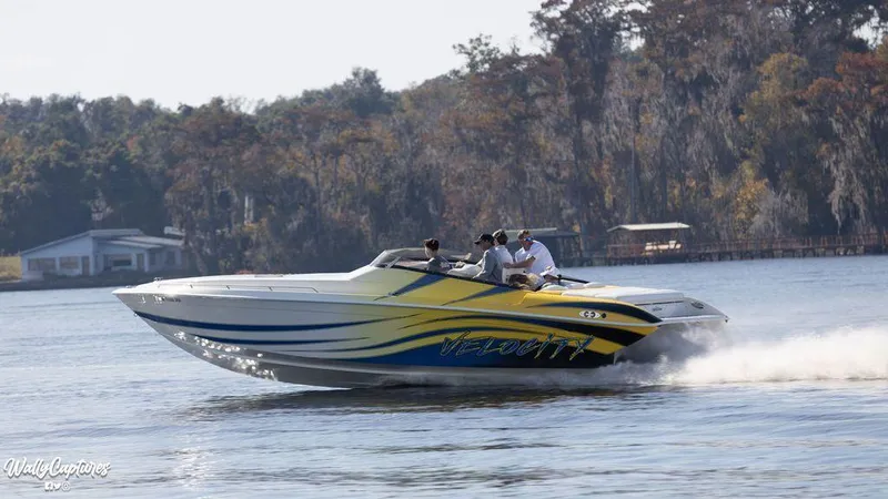 Slide: The Image of 2024 Velocity 322SC speedboat cruising on a lake with passengers. - 3