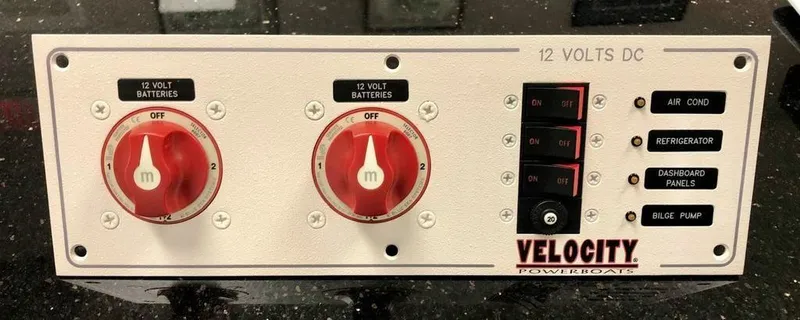 Slide: The Image of 2024 Velocity 322SC powerboat control panel with battery switches and labeled buttons. - 5