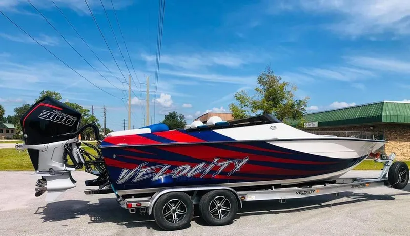 The Image of 2024 Velocity 260VR speedboat on trailer, vibrant red and blue design, powerful 300HP engine. - 0