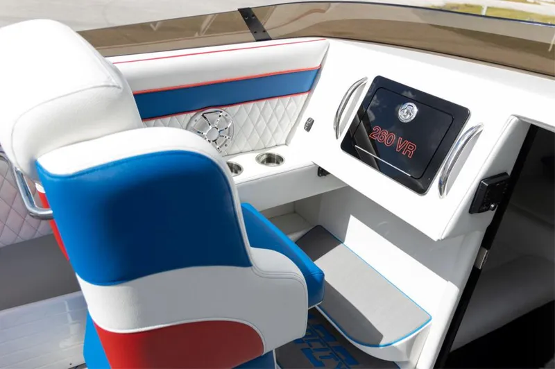 Slide: The Image of 2024 Velocity 260VR boat interior with modern dashboard and blue, white, and red seating. - 7
