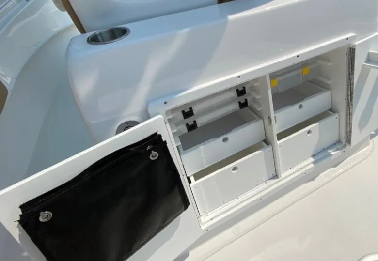 Slide: The Image of 2020 Cape Horn 24 XS boat storage compartments with open drawers and cup holder. - 21
