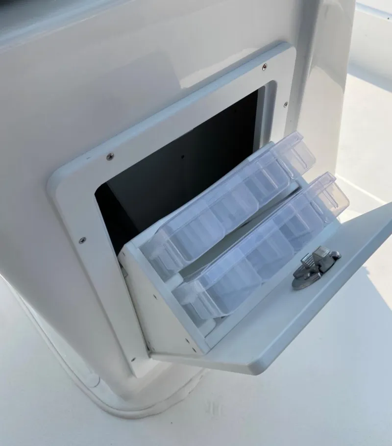 Slide: The Image of 2020 Cape Horn 24 XS boat storage compartment with tackle boxes. - 23