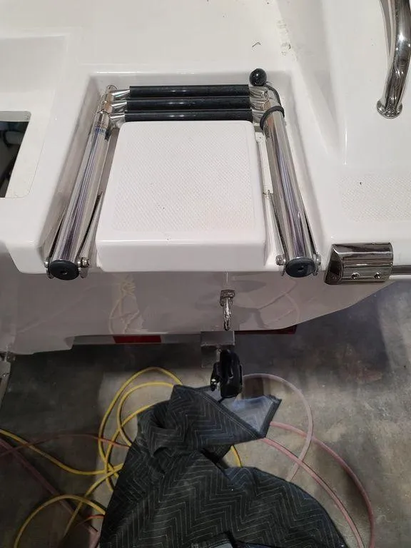 Slide: The Image of 2024 Velocity 262 CC boat with a folded swim ladder on the stern. - 23