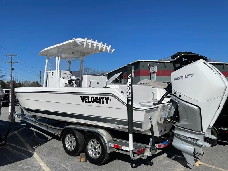 Slide: The Image of 2026 Velocity 262 CC boat with Mercury engine on a trailer under clear blue sky. - 3