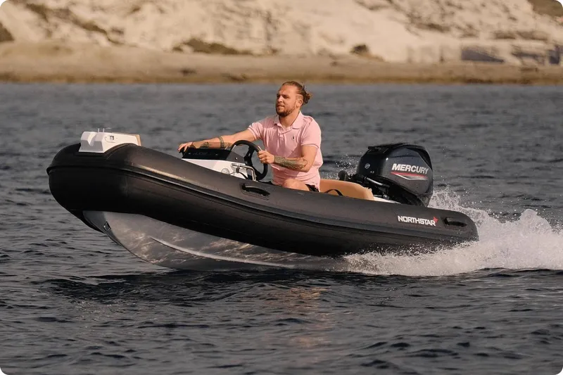 Slide: The Image of 2024 Northstar Axis 3.1 boat cruising on water with Mercury engine. - 6