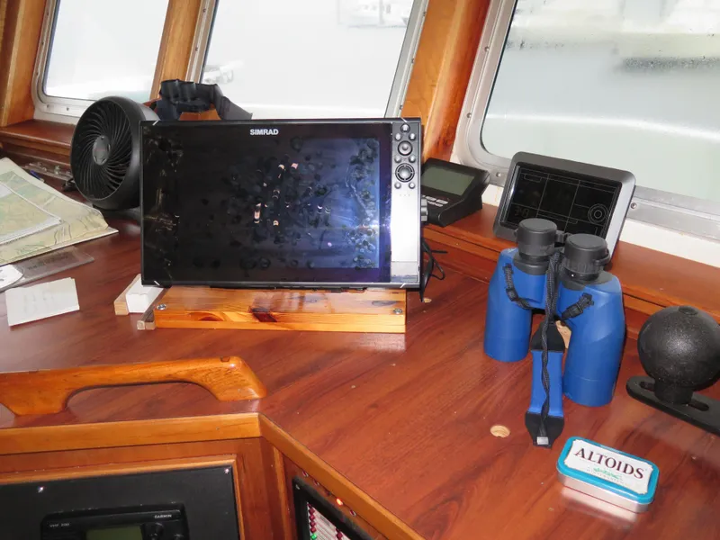 Slide: The Image of Boat navigation station with Simrad display, binoculars, and Altoids tin on wooden console. - 15