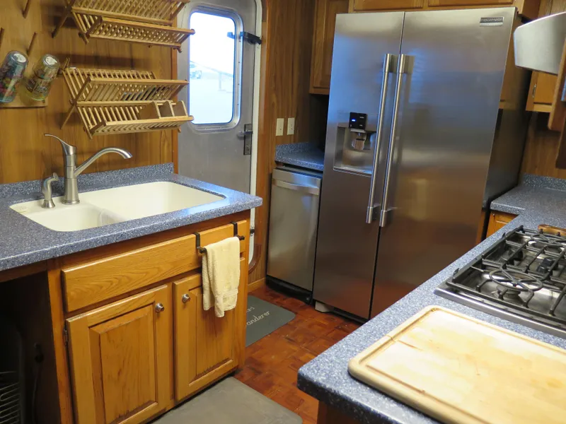 Slide: The Image of 1998 Rodriquez Custom kitchen with stainless steel fridge, gas stove, and wooden cabinets. - 16