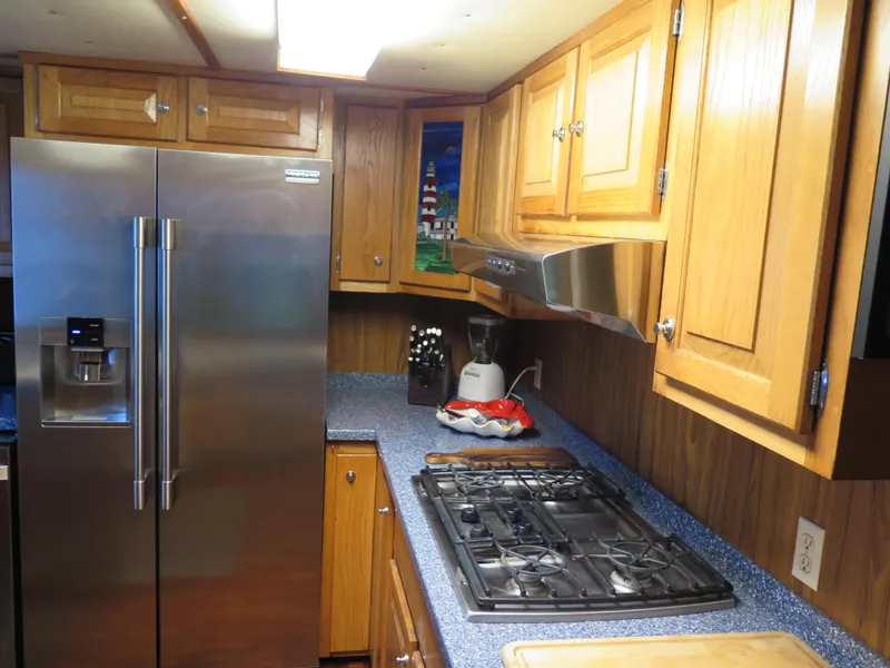 Slide: The Image of 1998 Rodriquez Custom kitchen with stainless steel fridge, gas stove, and wooden cabinets. - 19