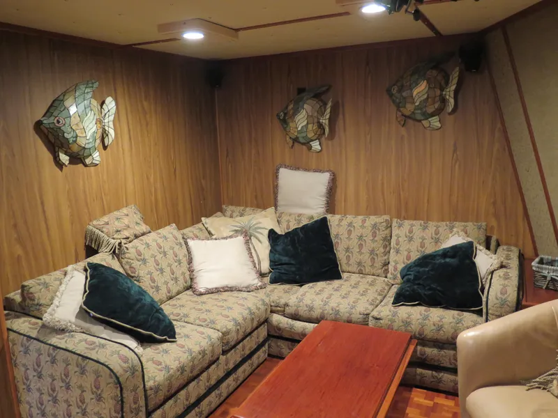 Slide: The Image of Cozy 1998 Rodriquez Custom boat lounge with floral sofa, wooden table, and fish wall decor. - 23