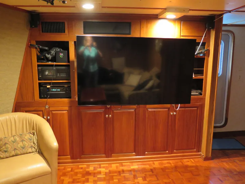 Slide: The Image of Luxurious 1998 Rodriquez Custom yacht interior with large TV and wooden cabinetry. - 25