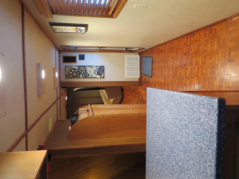 Slide: The Image of Interior of a 1998 Rodriquez Custom boat with wooden flooring and cozy decor. - 26