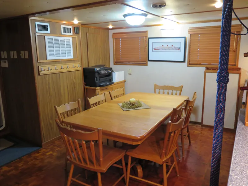 Slide: The Image of Dining area in a 1998 Rodriquez Custom boat with wooden table and chairs. - 28