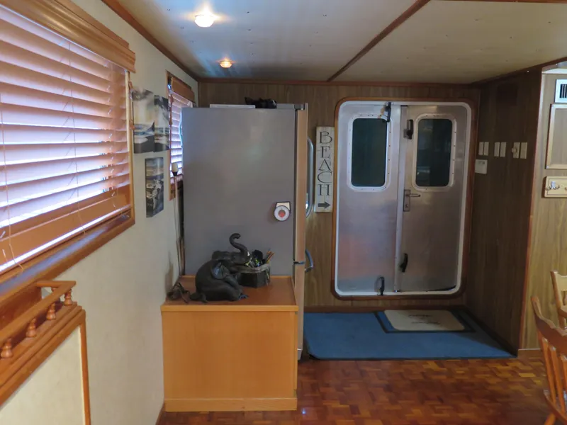 Slide: The Image of Interior of a 1998 Rodriquez Custom boat with wooden decor and metal door. - 29