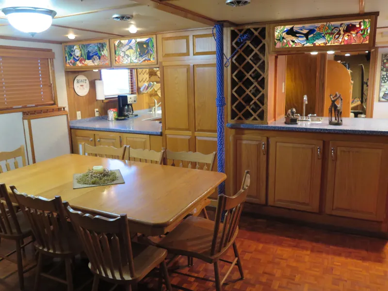 Slide: The Image of 1998 Rodriquez Custom yacht kitchen and dining area with wooden cabinets and stained glass accents. - 31