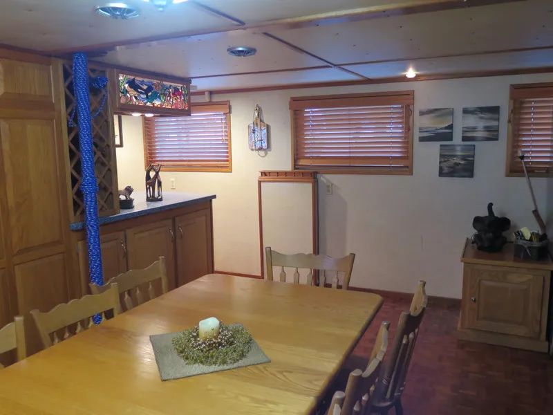 Slide: The Image of Cozy dining area in a 1998 Rodriquez Custom boat with wooden furniture and decor. - 39