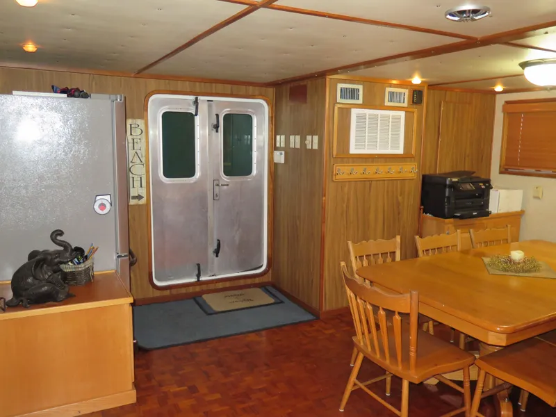 Slide: The Image of 1998 Rodriquez Custom boat interior with dining area, wooden furniture, and air conditioning unit. - 40