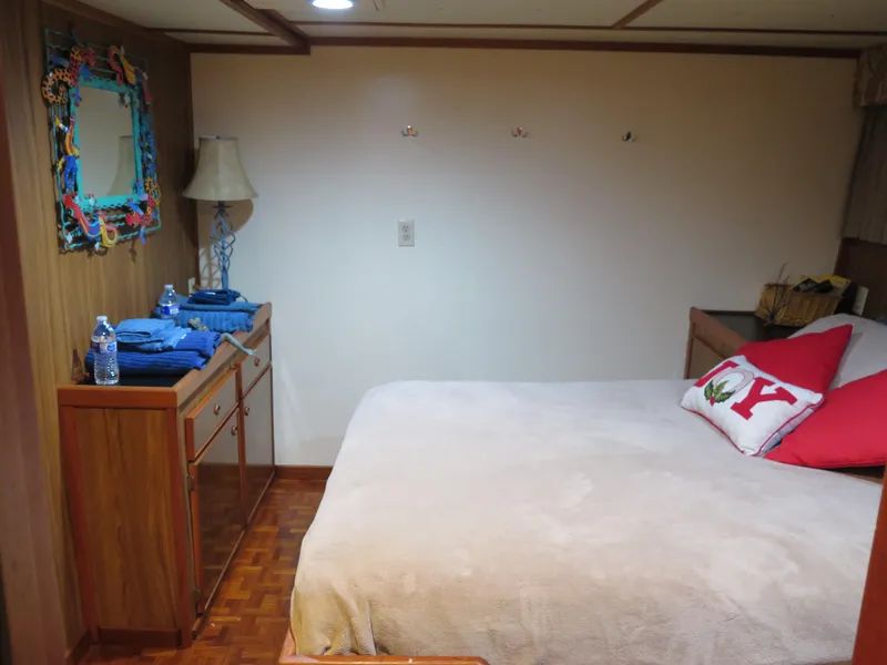 Slide: The Image of Cozy bedroom in a 1998 Rodriquez Custom boat with a neatly made bed and wooden furniture. - 47