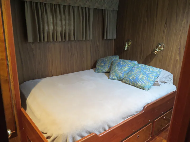Slide: The Image of Cozy bedroom in a 1998 Rodriquez Custom boat with wood paneling and built-in storage. - 49