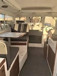 Slide: The Image of 2026 C-Dory TOMCAT 255 interior with seating, table, and helm. - 10