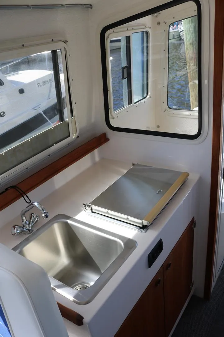 Slide: The Image of 2026 C-Dory TOMCAT 255 boat interior with sink and window. - 12