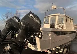 Slide: The Image of 2026 C-Dory TOMCAT 255 boat with dual Suzuki outboard motors on a trailer. - 6