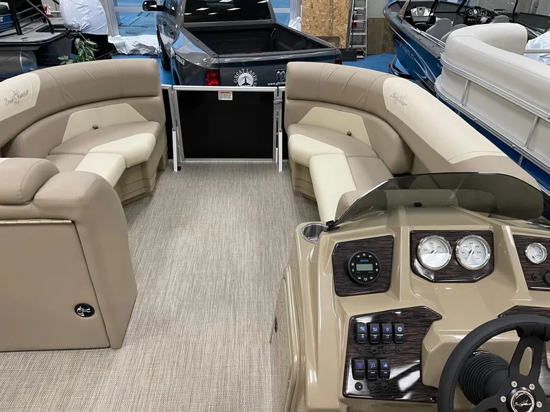 Slide: The Image of 2022 SunChaser Geneva Cruise 22 LR PSB pontoon boat interior with beige seating and control panel. - 4