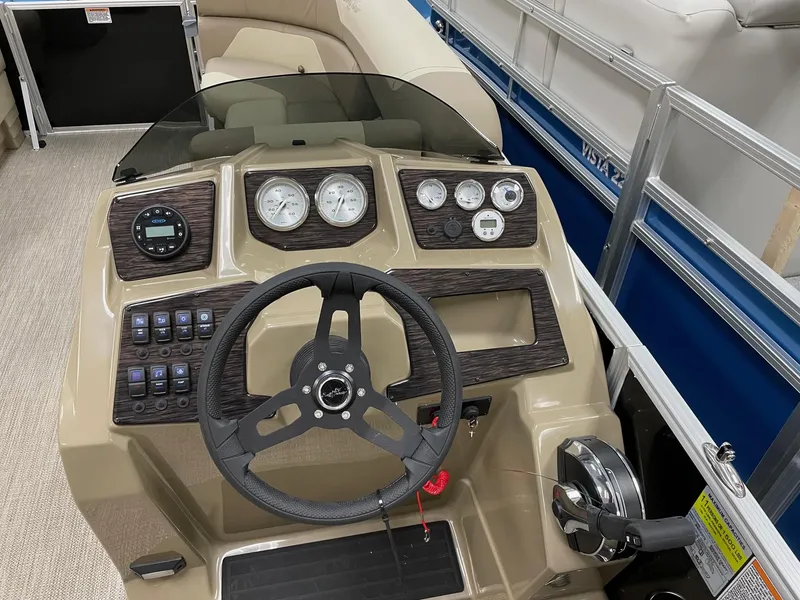Slide: The Image of 2022 SunChaser Geneva Cruise 22 LR PSB boat dashboard with steering wheel and control panel. - 5