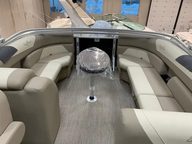 Slide: The Image of 2022 SunChaser Geneva Cruise 22 LR PSB boat interior with beige seating and a central table. - 7