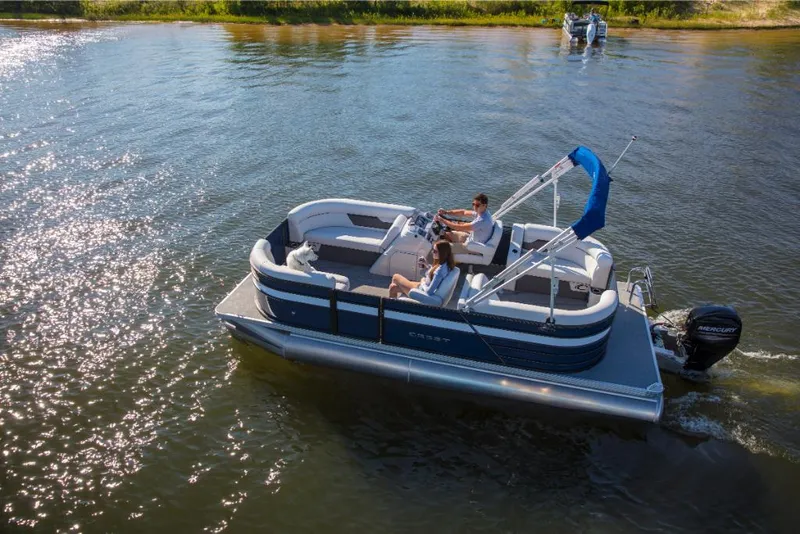 Slide: The Image of 2023 Crest Classic LX pontoon boat cruising on a sunny lake. - 0