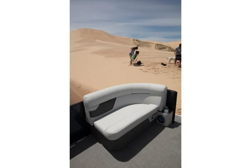 Slide: The Image of 2023 Crest Classic LX boat interior with white seating, sandy beach background. - 18