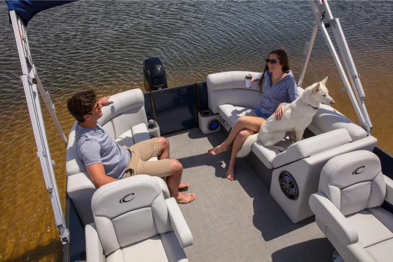 Slide: The Image of 2023 Crest Classic LX pontoon boat with passengers and a dog on a lake. - 20