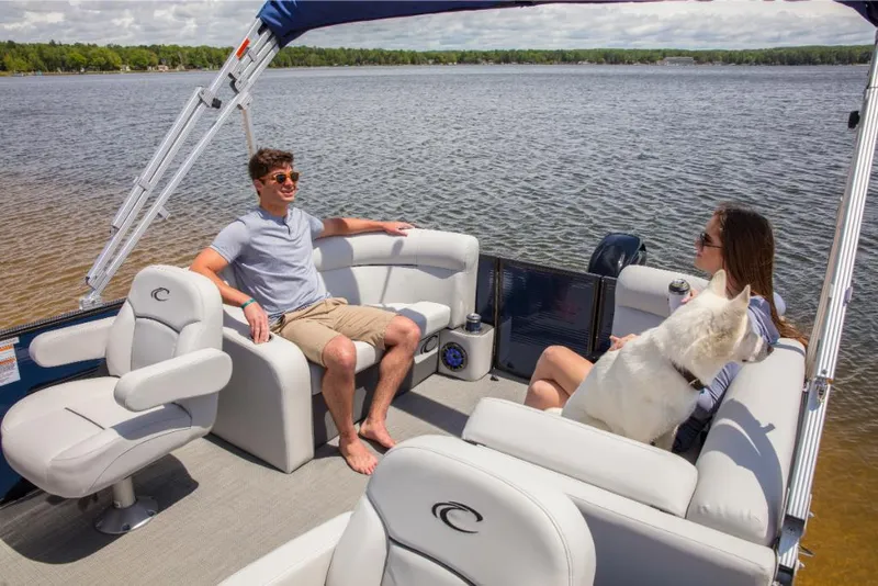 Slide: The Image of 2023 Crest Classic LX pontoon boat with passengers and a dog on a lake. - 21