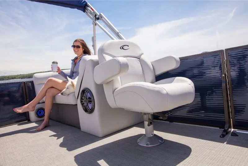 Slide: The Image of 2023 Crest Classic LX boat interior with woman relaxing, holding a drink. - 23