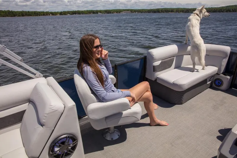 Slide: The Image of Woman and dog enjoying a ride on a 2023 Crest Classic LX pontoon boat. - 24