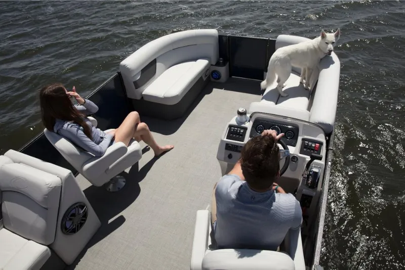 Slide: The Image of 2023 Crest Classic LX boat on water with two people and a dog. - 25