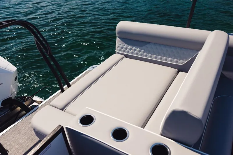 Slide: The Image of 2023 Crest Classic DLX boat with luxurious seating and cup holders on a sunny day. - 5