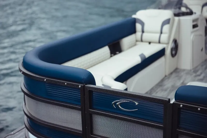 Slide: The Image of 2023 Crest Caribbean LX boat with blue and white seating on water. - 6