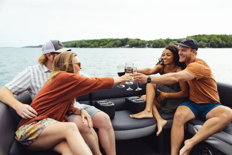 Slide: The Image of Friends toasting on a 2023 Crest Caribbean RS boat on a lake. - 6
