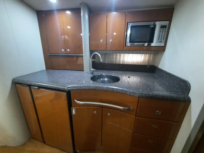 Slide: The Image of 2008 Formula 40 PC yacht kitchen with microwave, sink, and wooden cabinets. - 21