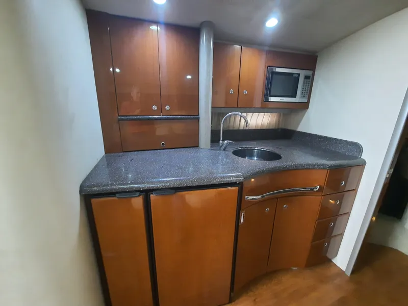 Slide: The Image of 2008 Formula 40 PC yacht kitchen with wooden cabinets, granite countertop, sink, and microwave. - 22