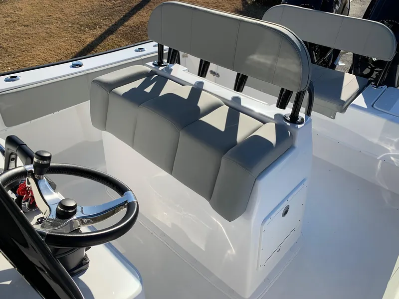 Slide: The Image of 2024 Cape Horn 24 XS boat interior with steering wheel and cushioned seating. - 11