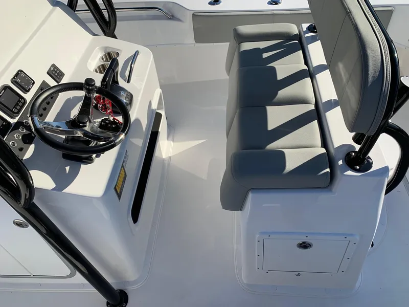 Slide: The Image of 2024 Cape Horn 24 XS boat cockpit with steering wheel and cushioned seating. - 10