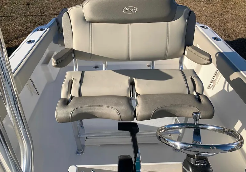 Slide: The Image of 2026 Key West 239 FS boat interior with cushioned seating and steering wheel. - 6