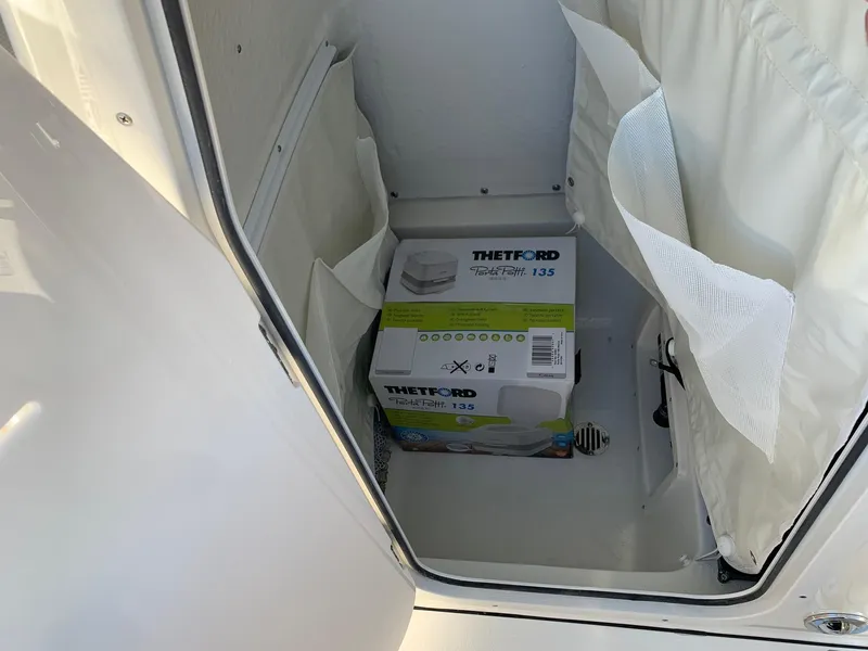 Slide: The Image of Storage compartment on a 2026 Key West 239 FS boat with Thetford Porta Potti. - 13